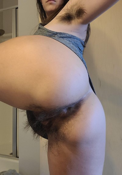 Junge Frau zeigt stark behaarte Muschi Bilder